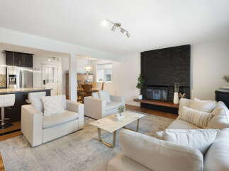 Experience modern living in this beautifully appointed open-concept home, featuring a sleek kitchen with stainless steel appliances and a breakfast bar.