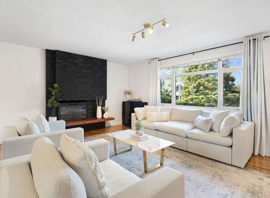 Experience modern living in this bright and airy living room, featuring a striking black brick fireplace as the focal point.