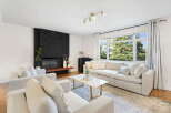 Experience modern living in this bright and airy living room, featuring a striking black brick fireplace as the focal point.