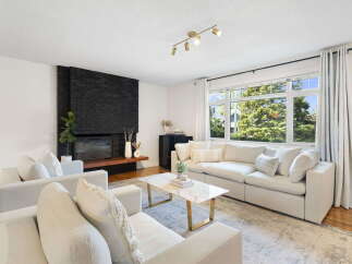 Experience modern living in this bright and airy living room, featuring a striking black brick fireplace as the focal point.