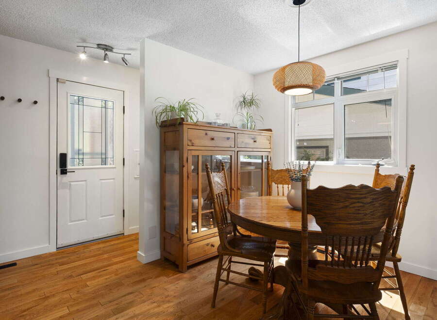 Step into this charming dining area, featuring a beautiful wooden hutch and a round oak dining table perfect for family gatherings.