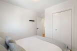 This bedroom features a comfortable bed with plush pillows and a cozy grey throw blanket, perfect for relaxation.