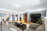 This finished basement offers a versatile living space with a large sectional sofa perfect for movie nights.