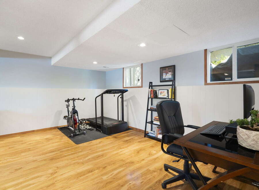 This versatile finished basement offers a dedicated home gym space with a treadmill and stationary bike, perfect for your fitness routine.