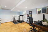 This versatile finished basement offers a dedicated home gym space with a treadmill and stationary bike, perfect for your fitness routine.