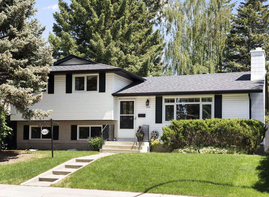 Charming white siding home with black shutters and a welcoming front entrance.