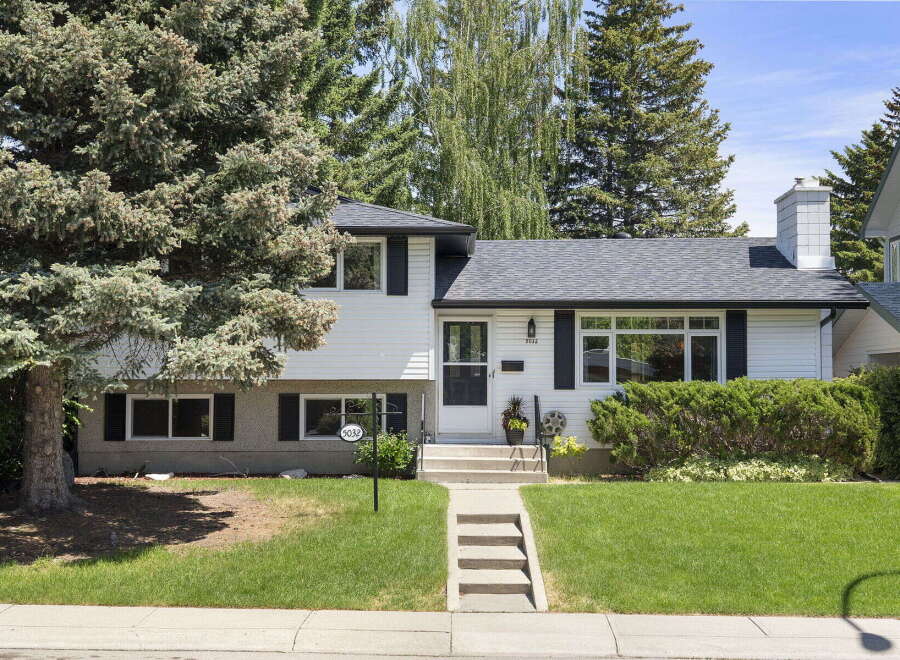 Charming white siding home with black shutters and a welcoming front entrance.