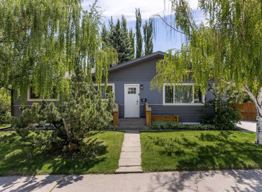 Charming bungalow with a freshly painted dark gray exterior and a welcoming white front door.