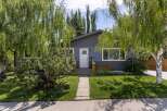 Charming bungalow with a freshly painted dark gray exterior and a welcoming white front door.