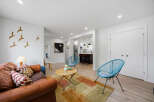 Experience modern living in this beautifully appointed open-concept space, featuring a stylish living area with a comfortable leather sofa and vibrant accent pillows.