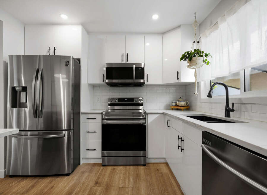 Experience modern living in this stunning kitchen featuring sleek white cabinetry and a durable quartz countertop.