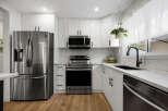 Experience modern living in this stunning kitchen featuring sleek white cabinetry and a durable quartz countertop.