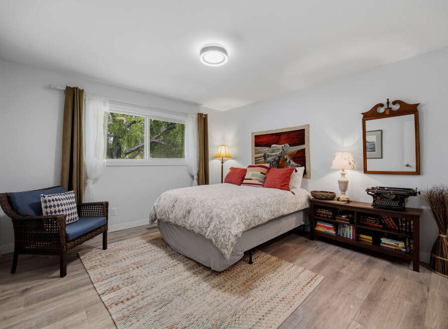 This charming bedroom features a comfortable queen-size bed with a decorative duvet and accent pillows, creating a cozy retreat.