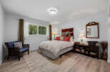 This charming bedroom features a comfortable queen-size bed with a decorative duvet and accent pillows, creating a cozy retreat.
