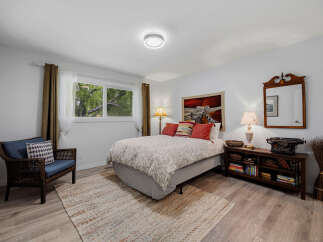 This charming bedroom features a comfortable queen-size bed with a decorative duvet and accent pillows, creating a cozy retreat.