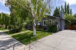 Charming single-story home featuring a welcoming front entrance with wooden steps and planters.