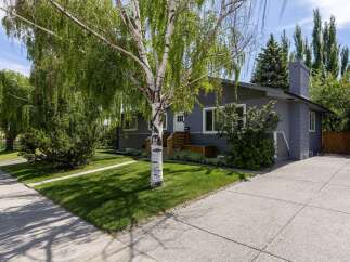Charming single-story home featuring a welcoming front entrance with wooden steps and planters.
