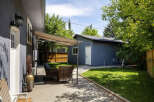 Enjoy outdoor living in this charming backyard featuring a spacious patio area with comfortable seating and a shaded canopy.