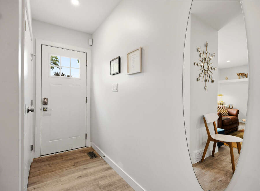 Step into this inviting entryway featuring a bright white door with a glass pane, offering a glimpse of the outdoors.