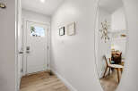 Step into this inviting entryway featuring a bright white door with a glass pane, offering a glimpse of the outdoors.