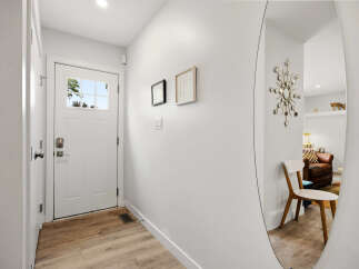 Step into this inviting entryway featuring a bright white door with a glass pane, offering a glimpse of the outdoors.