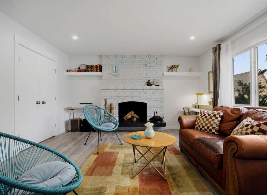 This inviting living room features a cozy brick fireplace, perfect for chilly evenings.