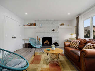 This inviting living room features a cozy brick fireplace, perfect for chilly evenings.