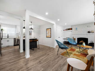 Discover modern living in this beautifully renovated open-concept space, featuring a sleek kitchen with stainless steel appliances and a stylish island perfect for casual dining.