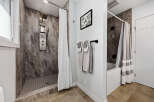 Experience modern luxury in this stunning bathroom featuring a sleek shower system with multiple jets and a rainfall showerhead.