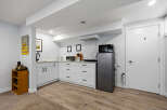 Discover this charming basement suite featuring a modern kitchenette equipped with a microwave, refrigerator, and ample cabinet space.