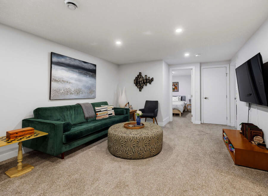 Experience modern comfort in this stylish living room, featuring a plush emerald green sofa perfect for relaxation.