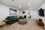Experience modern comfort in this stylish living room, featuring a plush emerald green sofa perfect for relaxation.