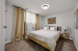 Discover comfort and style in this inviting bedroom, featuring a plush carpeted floor and elegant gold patterned curtains that add a touch of warmth.