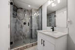 Experience modern luxury in this stunning bathroom, featuring a spacious walk-in shower with elegant marble-look tiles and a sleek black shower system.