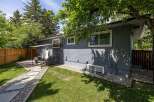 Enjoy outdoor living in this charming backyard featuring a paved patio area with comfortable seating, perfect for entertaining guests.