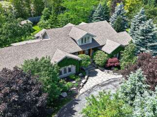Discover this stunning property featuring a beautifully landscaped yard with mature trees and lush greenery.