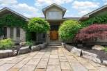 Discover this stunning home featuring a natural stone facade and lush landscaping.