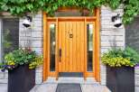 Enhance your home's curb appeal with this stunning entryway, featuring a warm, natural wood door complemented by elegant stone accents.