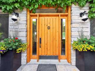 Enhance your home's curb appeal with this stunning entryway, featuring a warm, natural wood door complemented by elegant stone accents.
