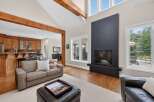 Experience luxury living in this stunning home featuring a grand living room with a soaring ceiling and exposed wooden beams.