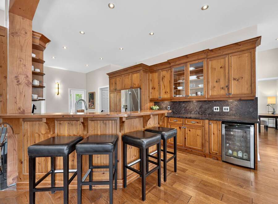 This spacious kitchen boasts a stunning wooden bar area, perfect for entertaining guests.