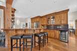 This spacious kitchen boasts a stunning wooden bar area, perfect for entertaining guests.