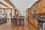 Experience rustic charm in this spacious kitchen featuring warm wooden cabinetry and exposed beams.