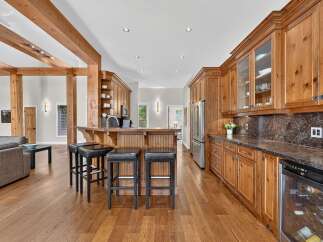 Experience rustic charm in this spacious kitchen featuring warm wooden cabinetry and exposed beams.