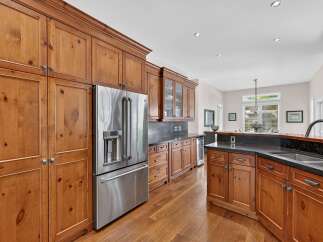 Experience the warmth and character of this stunning kitchen, featuring custom knotty pine cabinetry that exudes rustic charm.