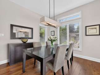 This elegant dining room features a dark wood dining table with upholstered chairs, perfect for hosting family and friends.