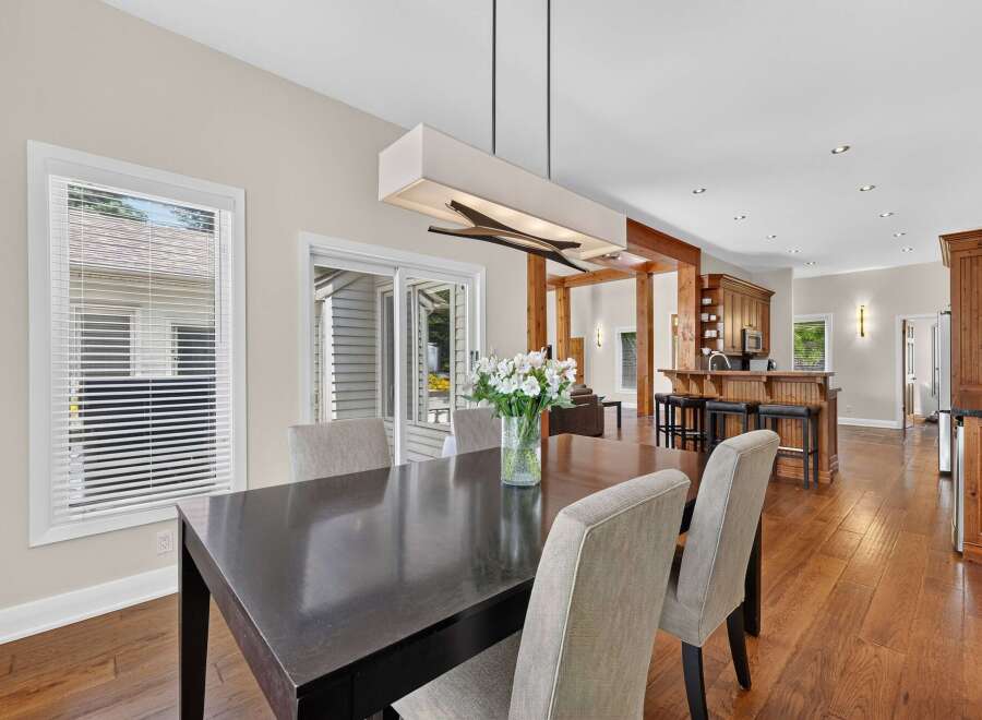 Experience seamless indoor-outdoor living with this stunning dining area, featuring a sleek dark wood table and comfortable upholstered chairs.