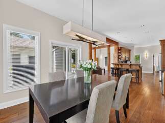 Experience seamless indoor-outdoor living with this stunning dining area, featuring a sleek dark wood table and comfortable upholstered chairs.