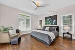 Experience modern comfort in this spacious bedroom, featuring a king-sized bed with luxurious grey bedding and a striking floral art piece above.