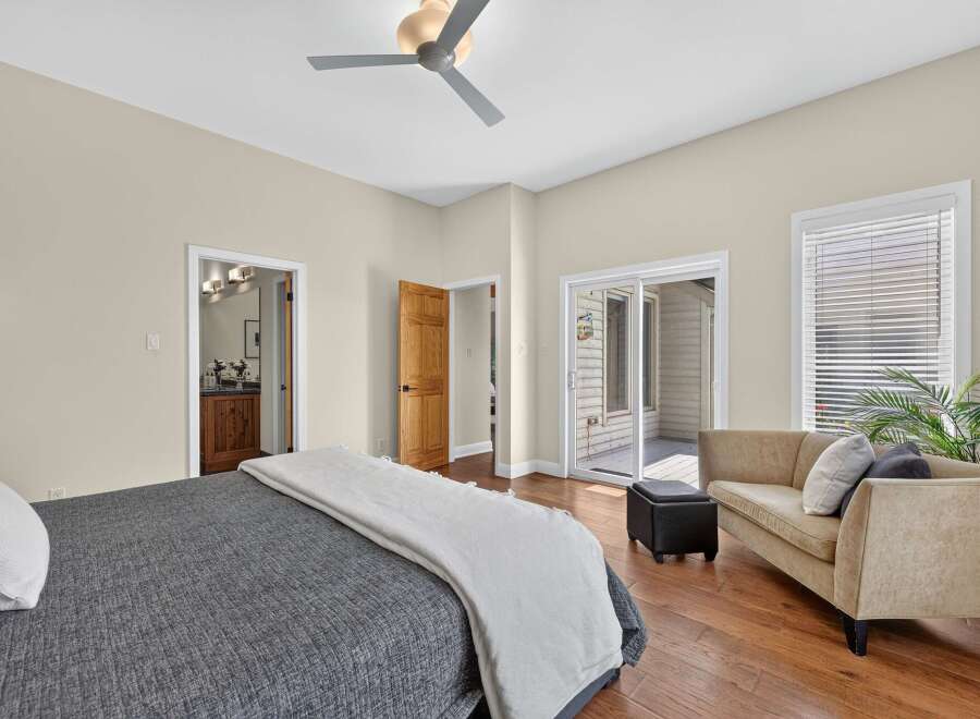 Step into this inviting bedroom featuring a comfortable bed with a dark grey textured comforter and a light grey throw.